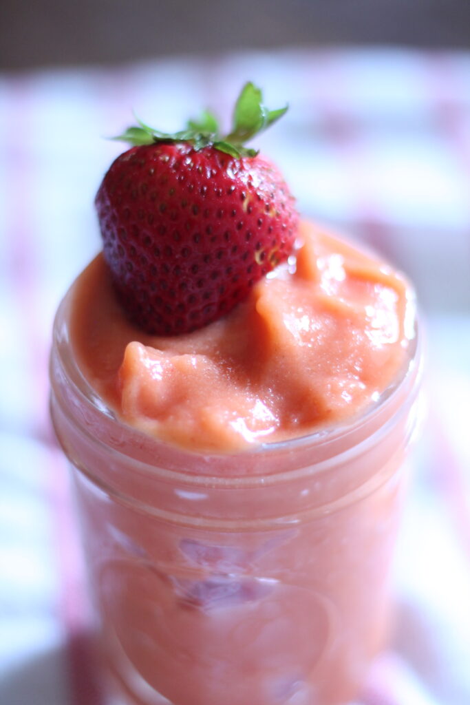 strawberry on top of smoothie in mason jar