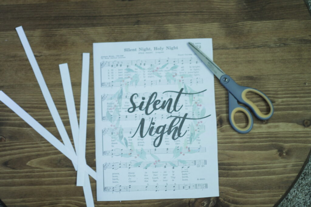 Silent night printed out on top of wooden table, with scissors and trimmed page edges 