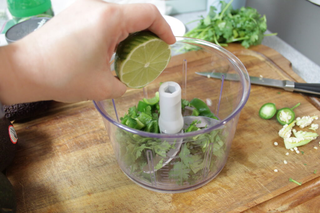 hand holding lime over food processor