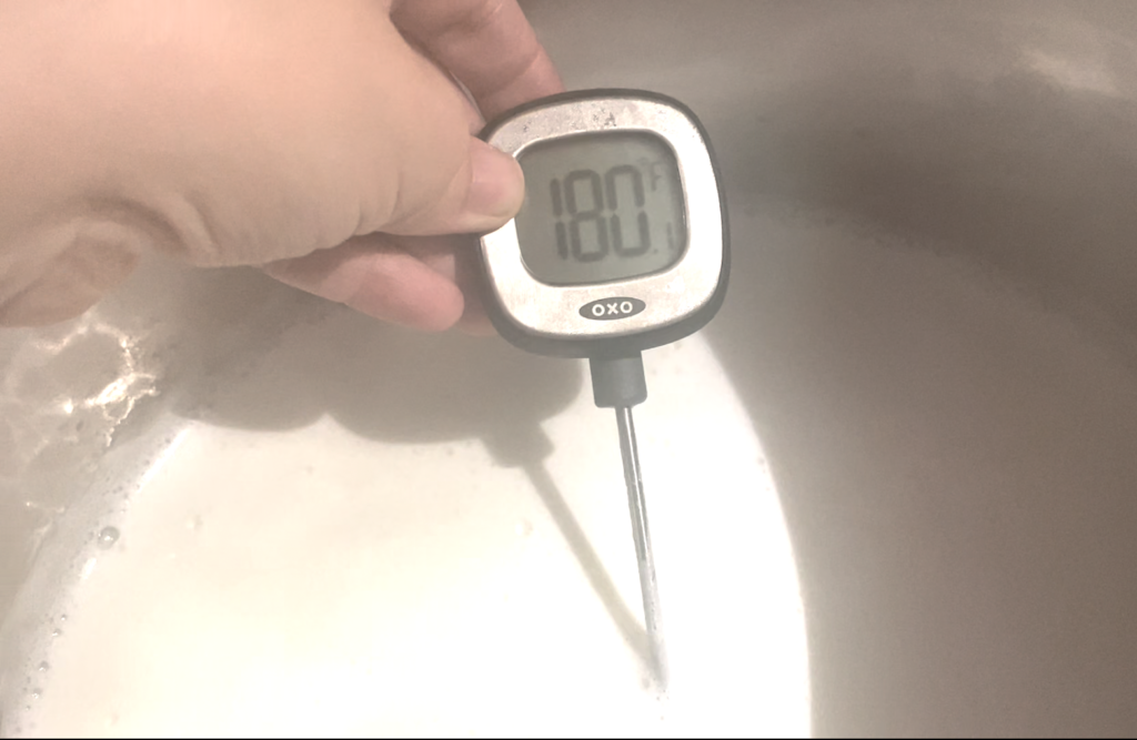 digital thermometer reading 180 in heated milk 