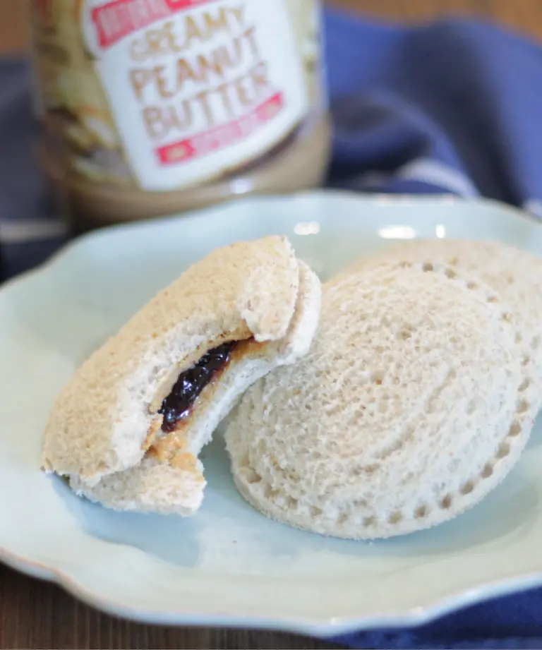 uncrustables on a blue plate with a bite taken out