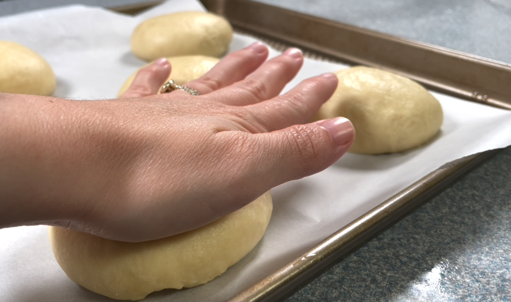 flattening dough with palm of hand 