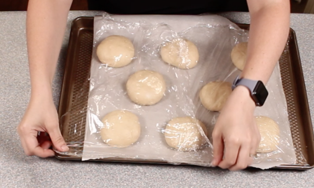 covering dough ball with plastic wrap