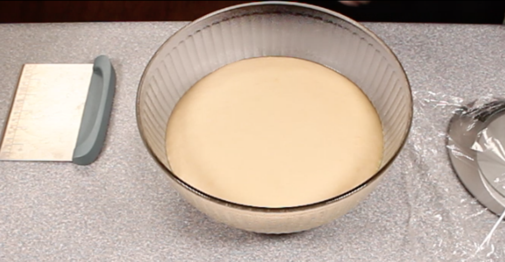 risen dough in glass bowl