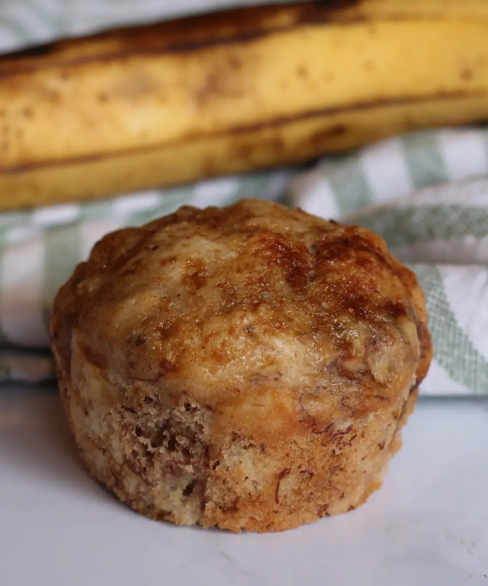 potato flake sourdough banana nut muffin sitting in front of a banana