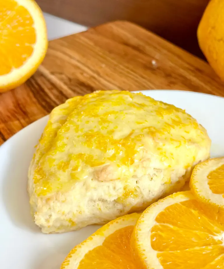 orange scone on white plate with orange slices