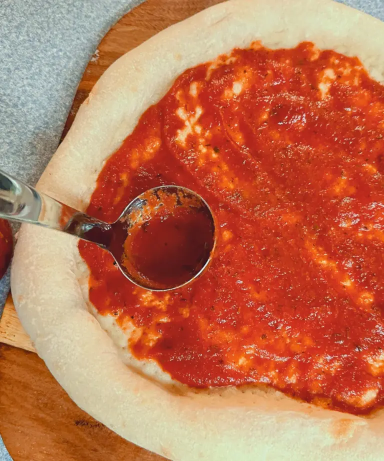 homemade pizza sauce on pizza crust